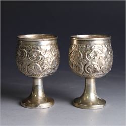 Pair of miniature Indian silver goblets, with embossed floral and foliate decoration, H6.5cm