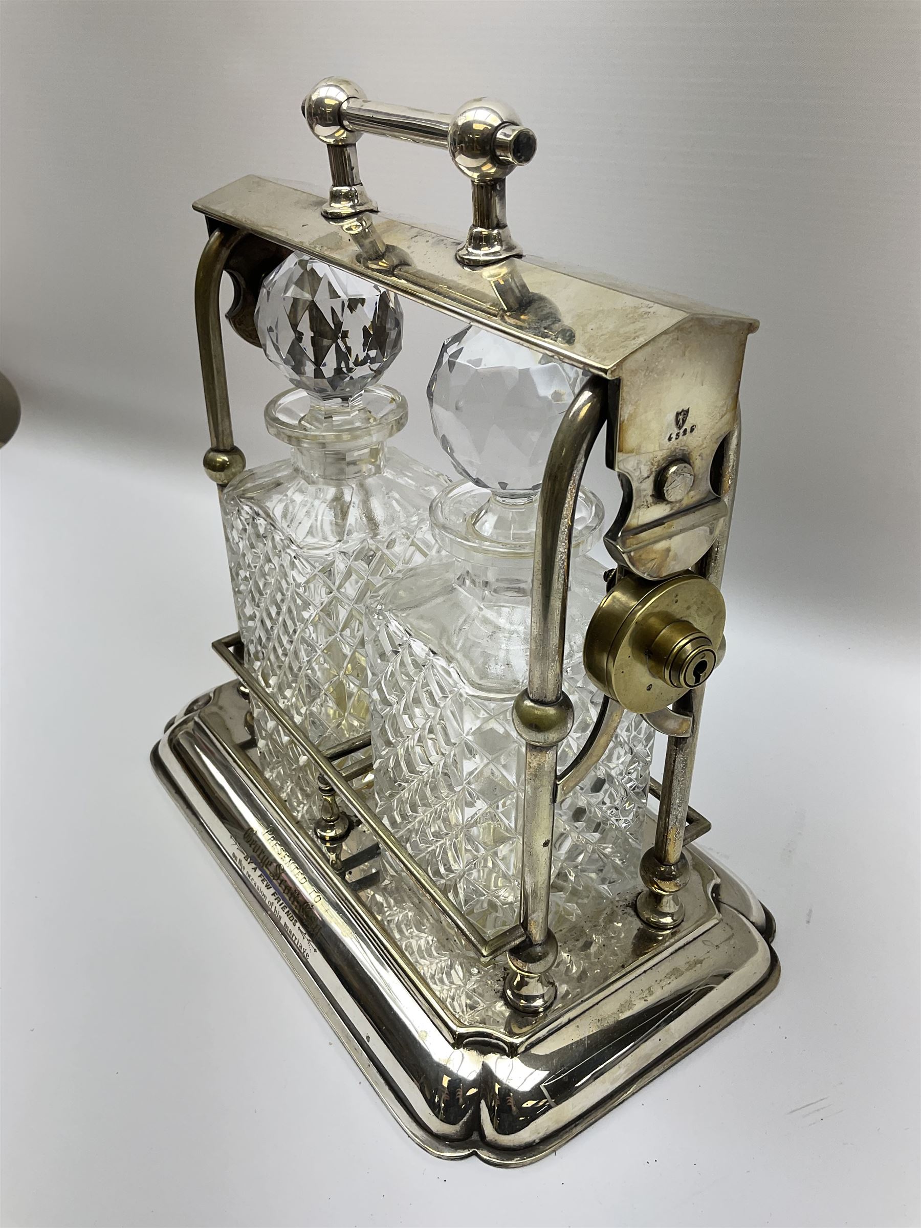 Early 20th century silver plated tantalus by John Grinsell & Sons of Birmingham, containing two crystal glass decanters, with key, H31cm