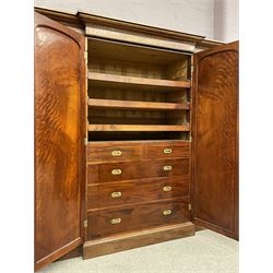 19th century figured mahogany quadruple breakfront press wardrobe, projecting cornice with banded frieze over arch panelled doors, the interior fitted with three sliding trays over two short and three long graduating drawers with recessed brass handles, flanked by two hanging cupboards with hooks