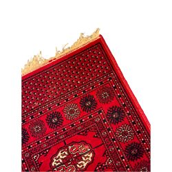 Persian design red ground runner, the field decorated with repeating Boteh motifs, five-band border (277cm x 74cm); Bokhara design red ground rug, decorated with a single row of Gul motifs (272cm x 69cm)