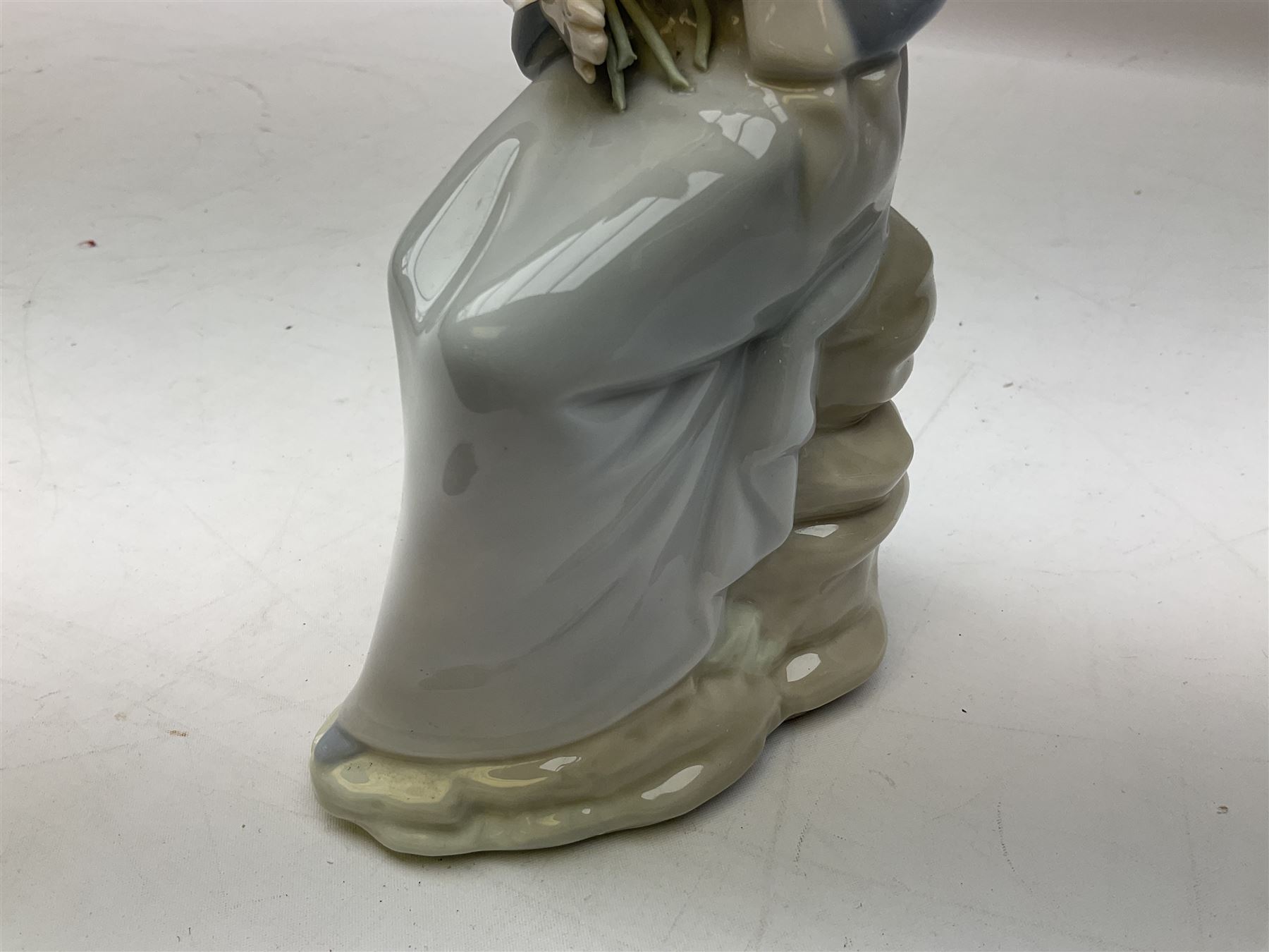 Four Lladro figures, comprising Afternoon Promenade no 7636, Nostalgia no 5071, both with original boxes, Girl with Lilies no 4972 and Madonna no 4534, largest example H27cm