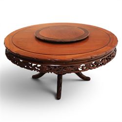 20th century Chinese ornately hardwood dining table and chairs, circular table with 'Lazy Susan' top with pierced carved frieze, raised on a quadriform base with carved foliate detail, the chairs en suite with carved pierced detailing  