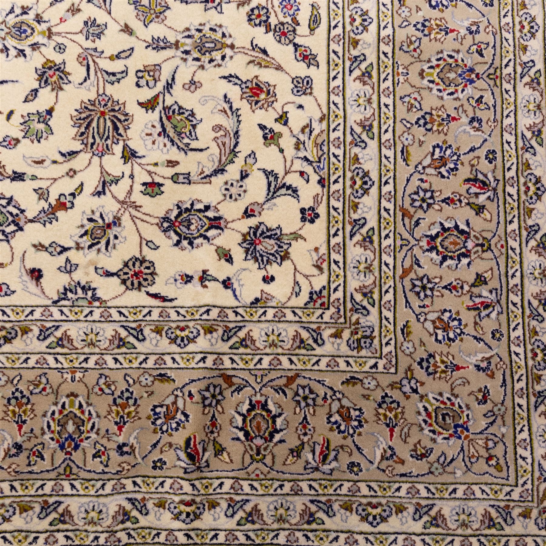 Central Persian Kashan hand-knotted carpet, ivory field densely decorated with an all-over design of scrolling floral vines and palmettes, framed by multiple borders with continuous floral meander and rosette motifs, in a palette of indigo, ivory, soft blue, sage green, rose and ochre tones, with cotton fringe ends 