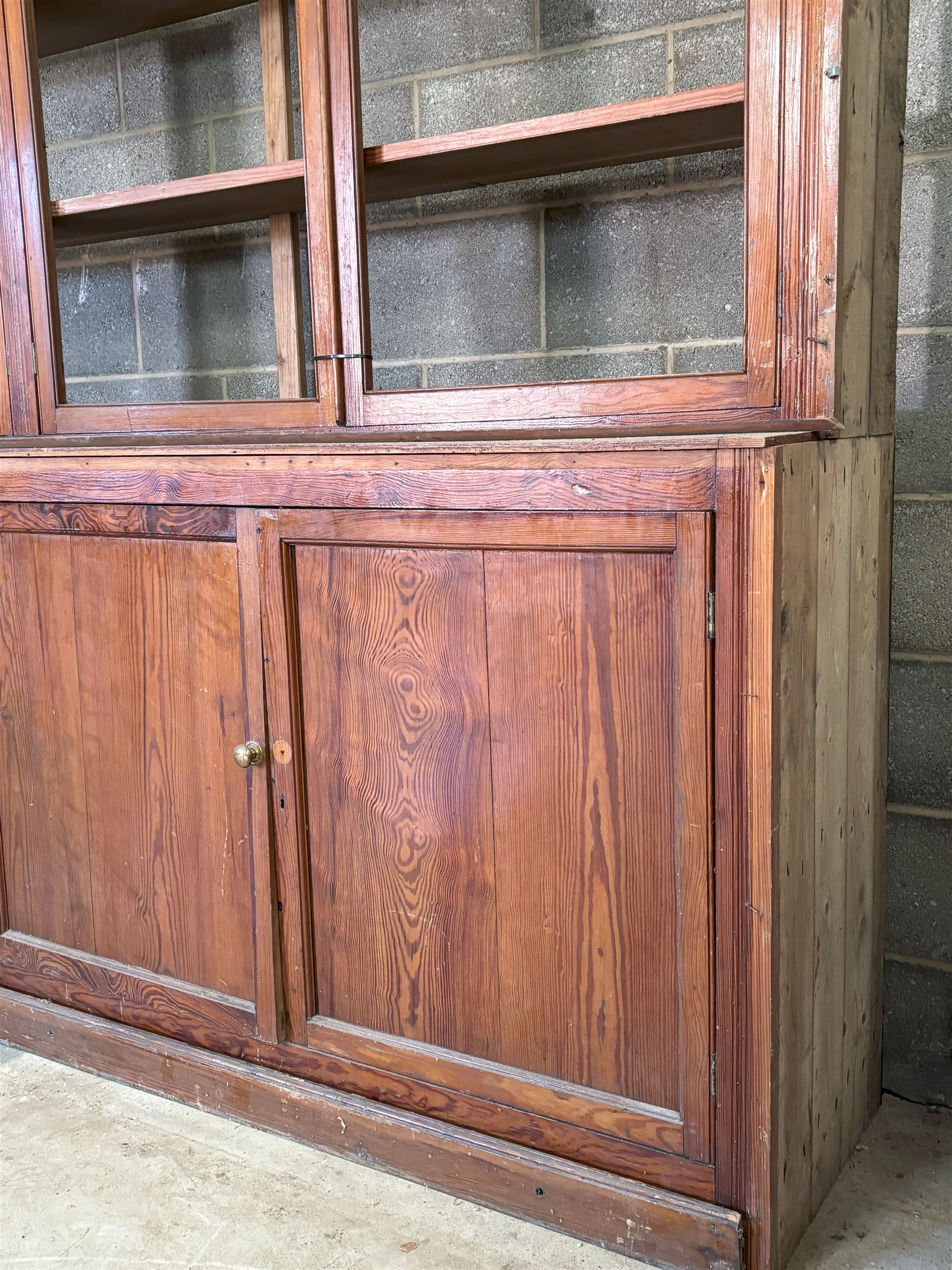 Large pitch pine library bookcase, early 20th century, the top fitted with six doors enclosing six shelves, above six panelled doors to base, for restoration. Splits in four for transportation.  H285cm, L426cm, D49cm - COLLECTION BY APPOINTMENT FROM: The White House, Thirsk Road, Easingwold, York, YO61 3NF - CALL 01723 507111 TO ARRANGE
