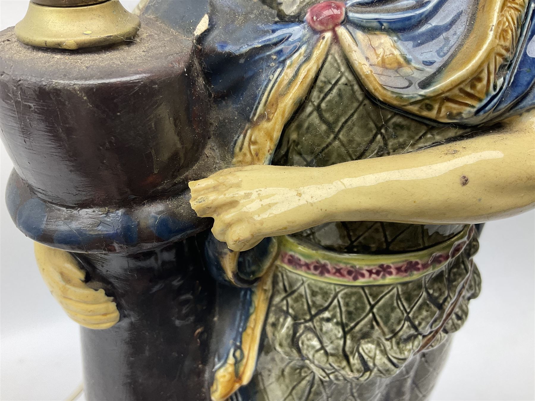 Composite table lamp modelled as a Roman Emperor donning blue robes, upon quatrefoil base modelled with rams heads and winged cherubs, H56cm excl fitting