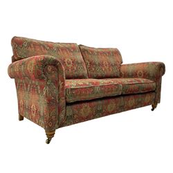 Duresta - 'Beaminster' grande two-seat sofa, traditional shape with rolled arms, upholstered in 'Althorp' russet and stone floral pattern fabric, on turned feet with brass castors
