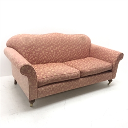 Wesley Barrell Hinton two seat sofa, shaped cresting rail, scrolling arms, turned supports on castors, W200cm