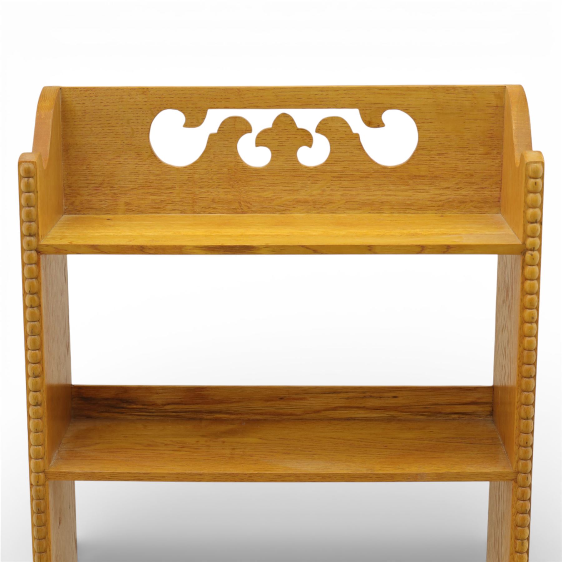 20th century small oak open bookcase, with pierced shaped cresting above four open shelves, beaded upright sides, shaped side panels, raised on shaped feet