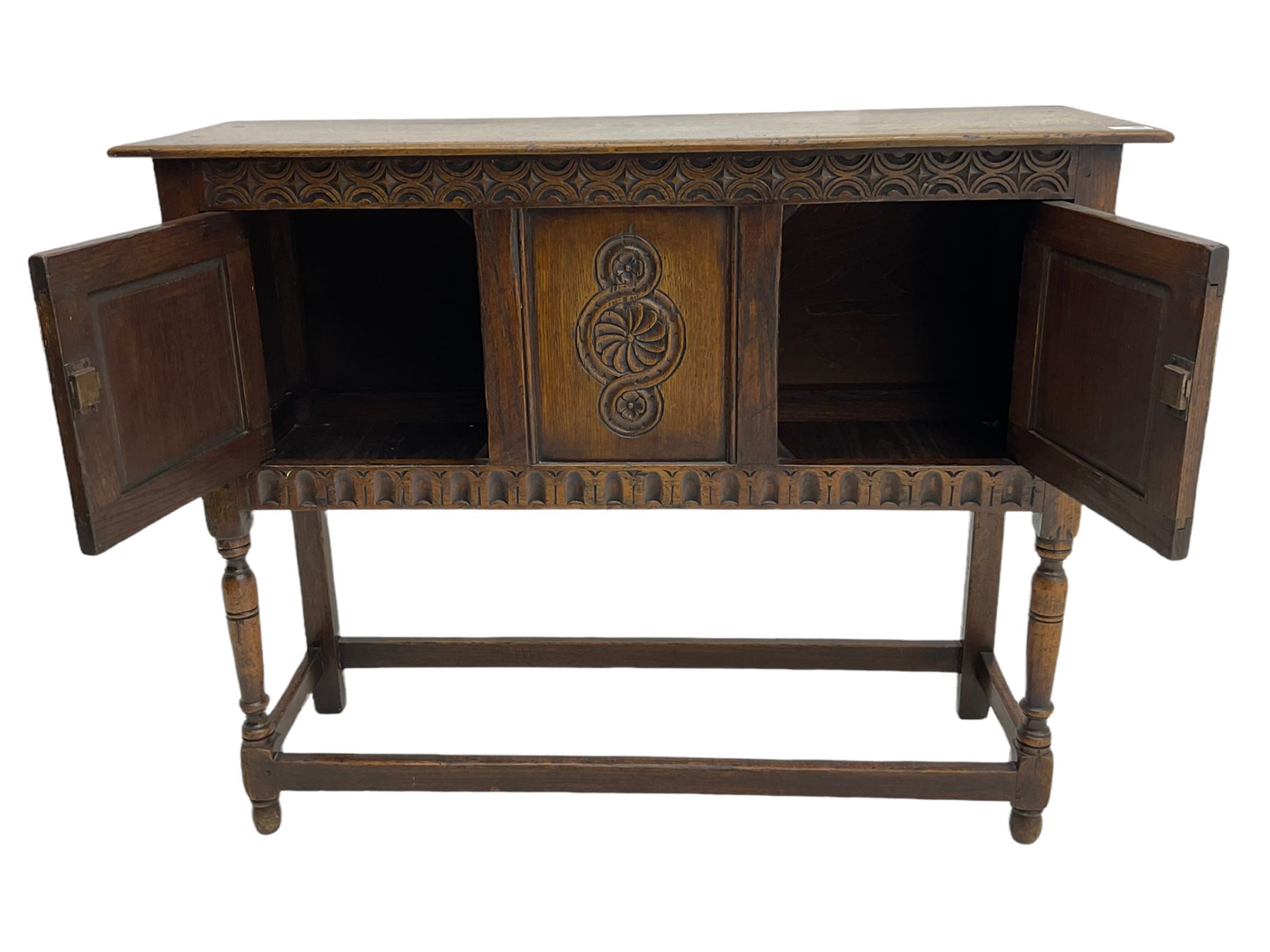 17th century style caved oak side cabinet, fitted with two cupboards, stretcher base