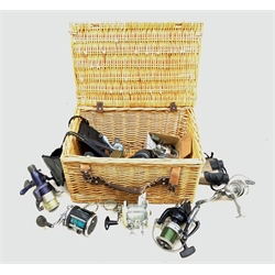  Wicker basket containing various fishing reels including Masterline 'Toothy Critter', Daiwa 'Windcast S5500', Rovex 'Altus LW20', Garcia 'Mitchell 604', various pairs of binoculars etc  