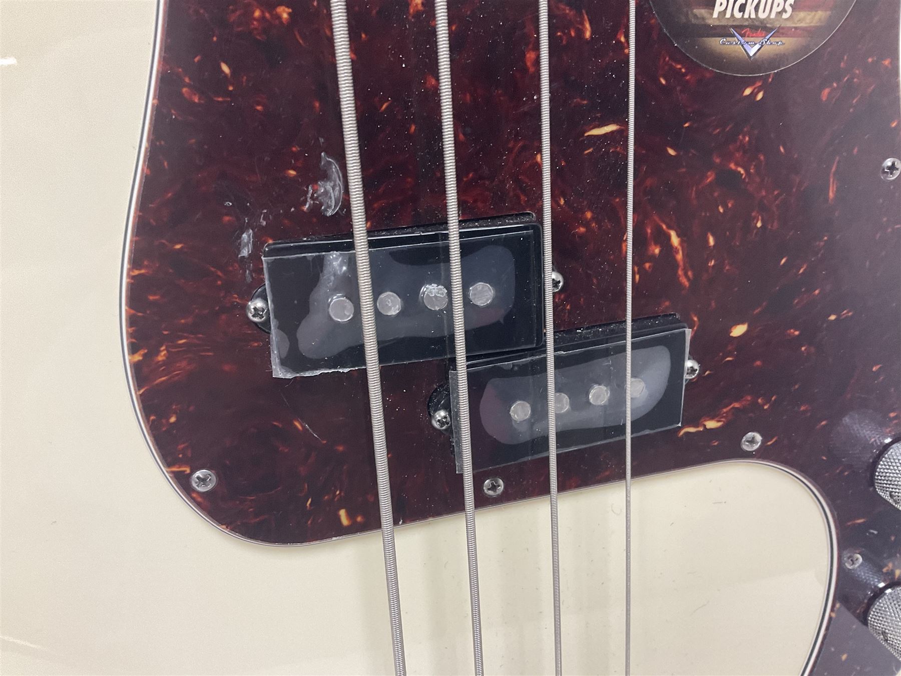 Fender Precision Bass guitar, in Olympic White finish with tortoiseshell effect scratchboard, serial no US15103092, in black Fender hard case with Fender strap and warranty card, guitar L116cm