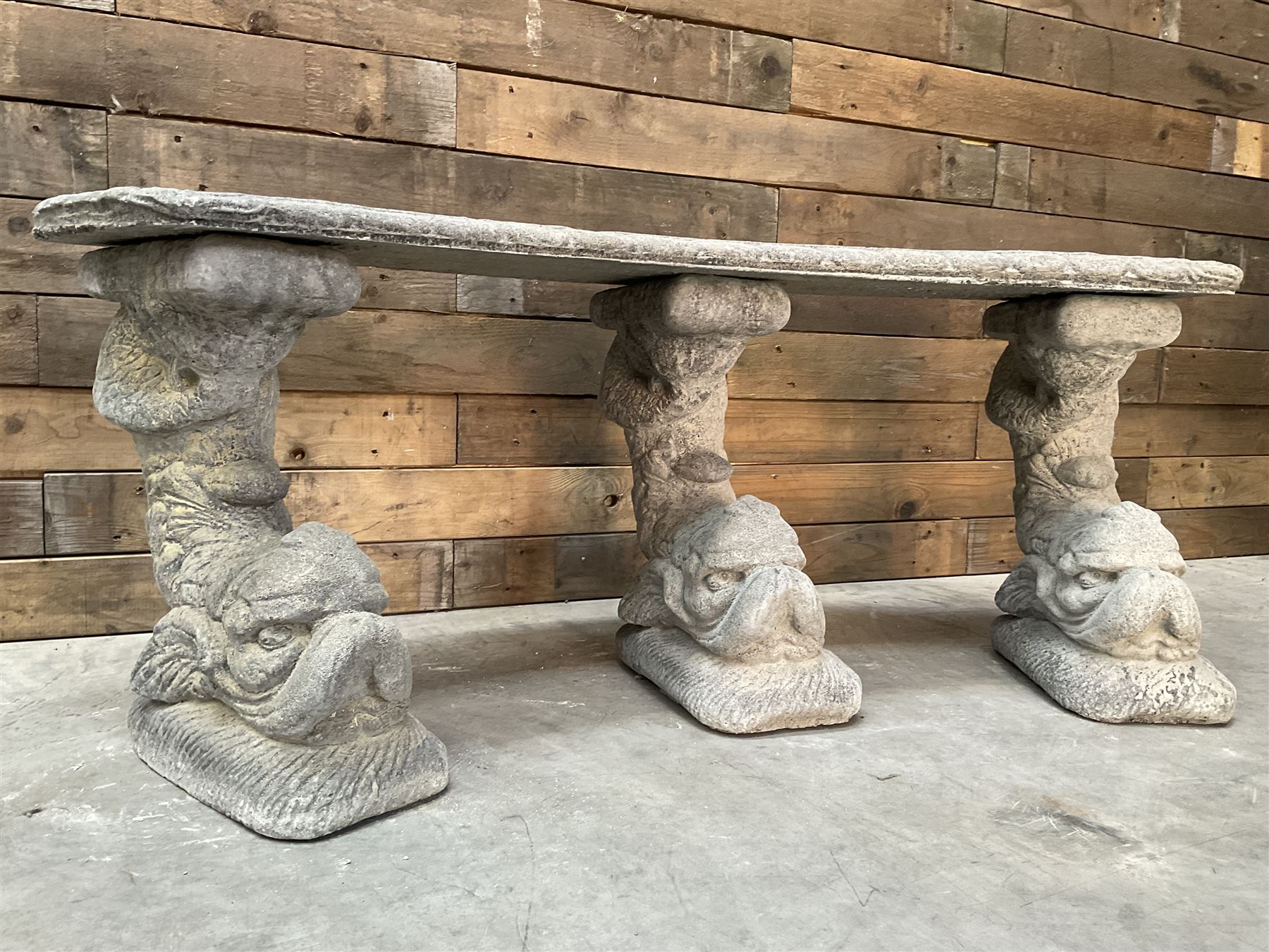 Cast stone four piece curved Dolphin bench, set with three dolphin pillars, curved rectangular slab top with detailed border