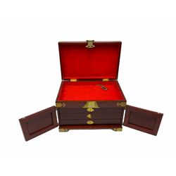 Chinese hardwood jewellery box mounted with engraved brass fixtures, the two exterior doors revealing three drawers below the hinged upper lid, lined with red material decorated with floral sprays, H25cm, W36cm, D23cm