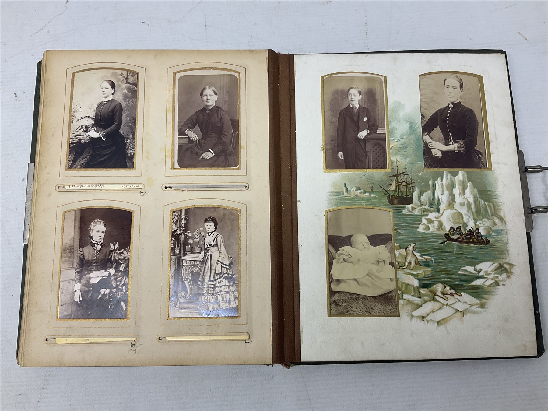 Victorian desk ink blotter, decorated with painted spray of flowers within stylised gilt rococo spandrels with mother of pearl fixings, together with a Victorian photo album containing interior leaves with apertures of various sizes and shapes of portraits surrounded by printed sea and dock scenes, blotter L28cm