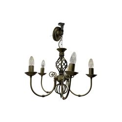 Pair of brass five-branch chandeliers, each featuring scrolling arms with candle-style light fittings, centred by a twisted openwork column, complete with ceiling roses and hanging chains