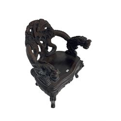 Japanese Meiji period open armchair, the back carved and pierced with dragon and scrolling scaled tails, projecting dragon carved arm terminals on scrolled supports, serpentine seat with decorative band, the apron and supports with scroll and chip-carved decoration
