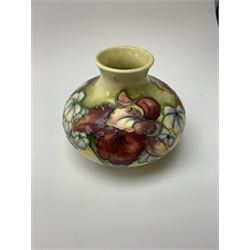 A Moorcroft vase, circa 1950, of squat bulbous form, decorated in the Orchid pattern upon a yellow glazed ground, with impressed and blue painted WM initials for Walter Moorcroft, H10.5cm. 