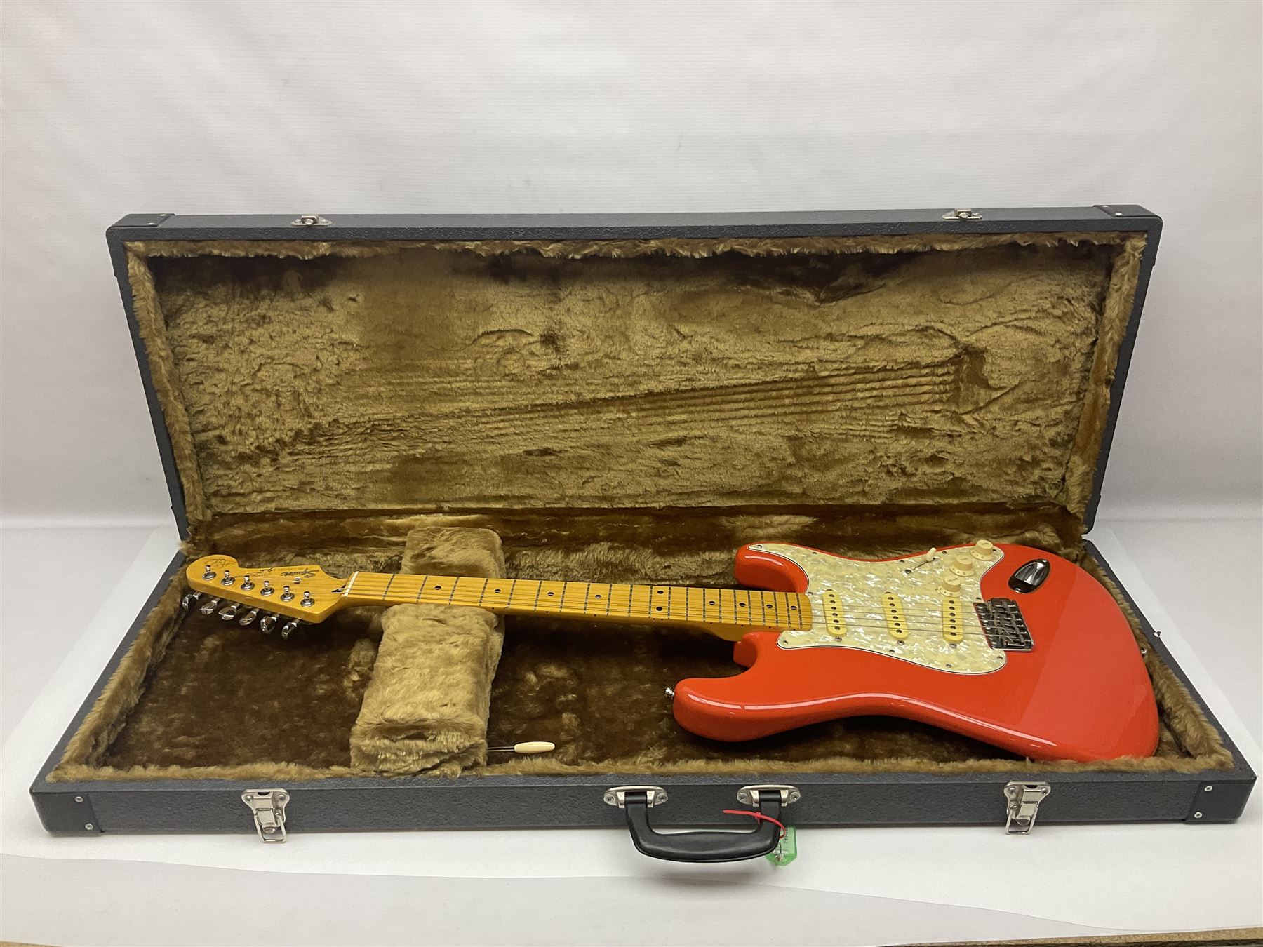 Japanese Squier Fender 'Hank Marvin' Stratocaster electric guitar, c1992, in Fiesta red with tremolo arm and facsimile signature decal; serial no.L037281, L98cm; in hard carrying case.
