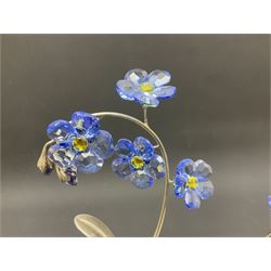 Eleven Swarovski Crystal flowers, to include violet, sunflower, delphinium, forget-me-not and lily-of-the-valley, each on stylised metal stems, tallest H23cm