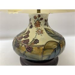 Moorcroft table lamp of squat baluster form, decorated in the Autumn Blackberry, with Moorcroft cream fabric shade with gold, green and red piping, overall H38cm