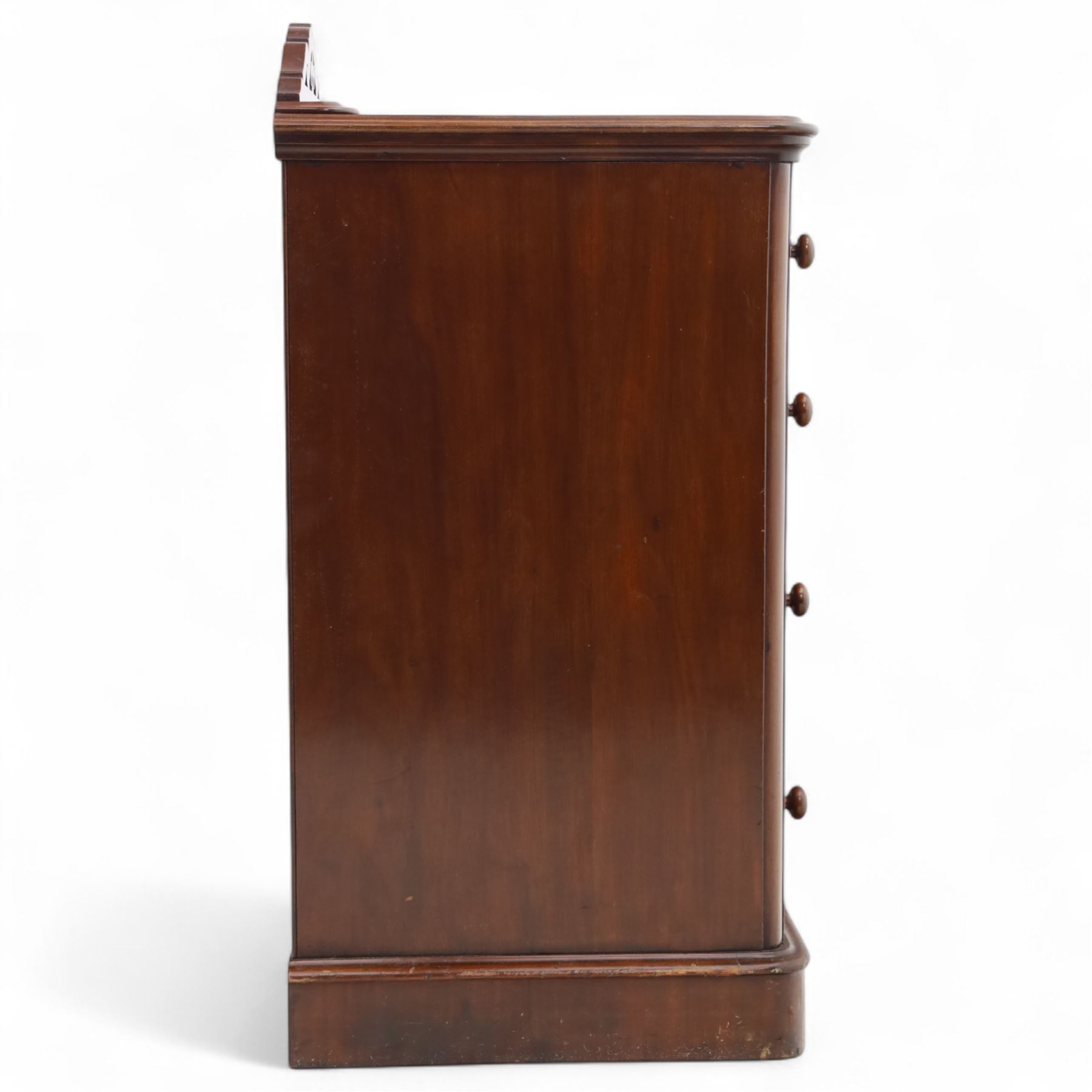 Pair of tall Victorian mahogany bedside chests, of narrow upright form, rectangular top with moulded edge, the back with raised pierced fretwork gallery, above four graduated drawers with knob handles, raised on a plinth base 