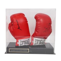 Muhammad Ali and George Foreman signed boxing gloves, two Everlast gloves the left hand glove signed by Ali and right signed by Foreman, both in black marker pen, in Perspex display case with plaque to base displayed with a further unsigned glove, each with Mounted Memories holographic stickers, case H36cm