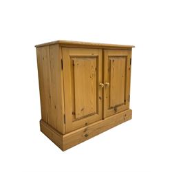 Traditional pine low cupboard, fitted with two panelled doors, on plinth base