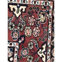 Persian Herati design indigo and red ground carpet, decorated with floral motifs, arched border