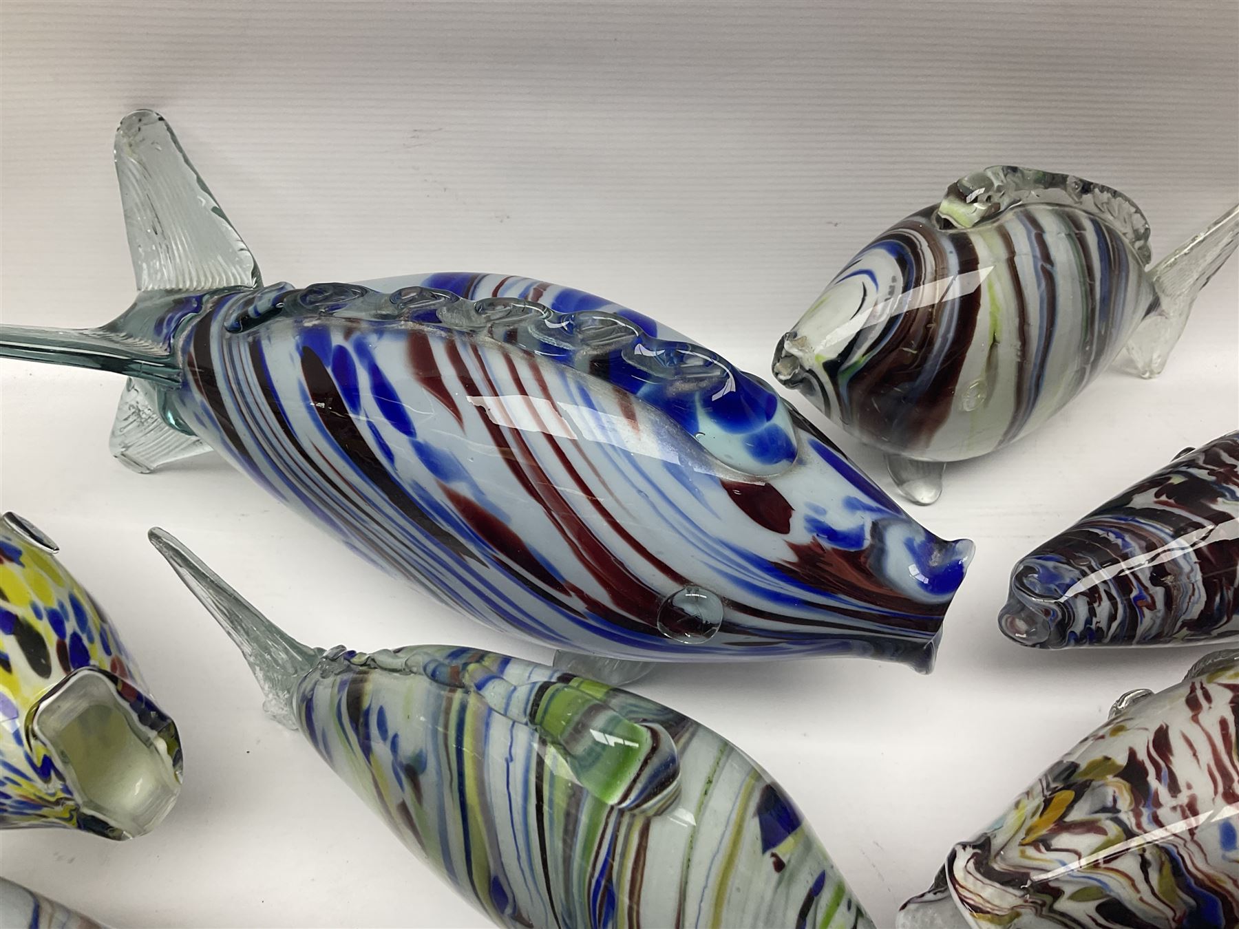 Collection of mid 20th century murano style glass fish, each with multi coloured inclusions largest L42cm