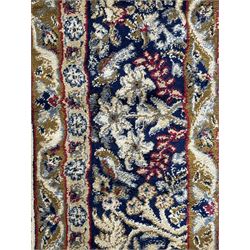 Persian Kerman ivory ground rug, the field adorned with naturalistic depictions of birds, animals and floral designs, framed by a multi-band border in blue and red tones