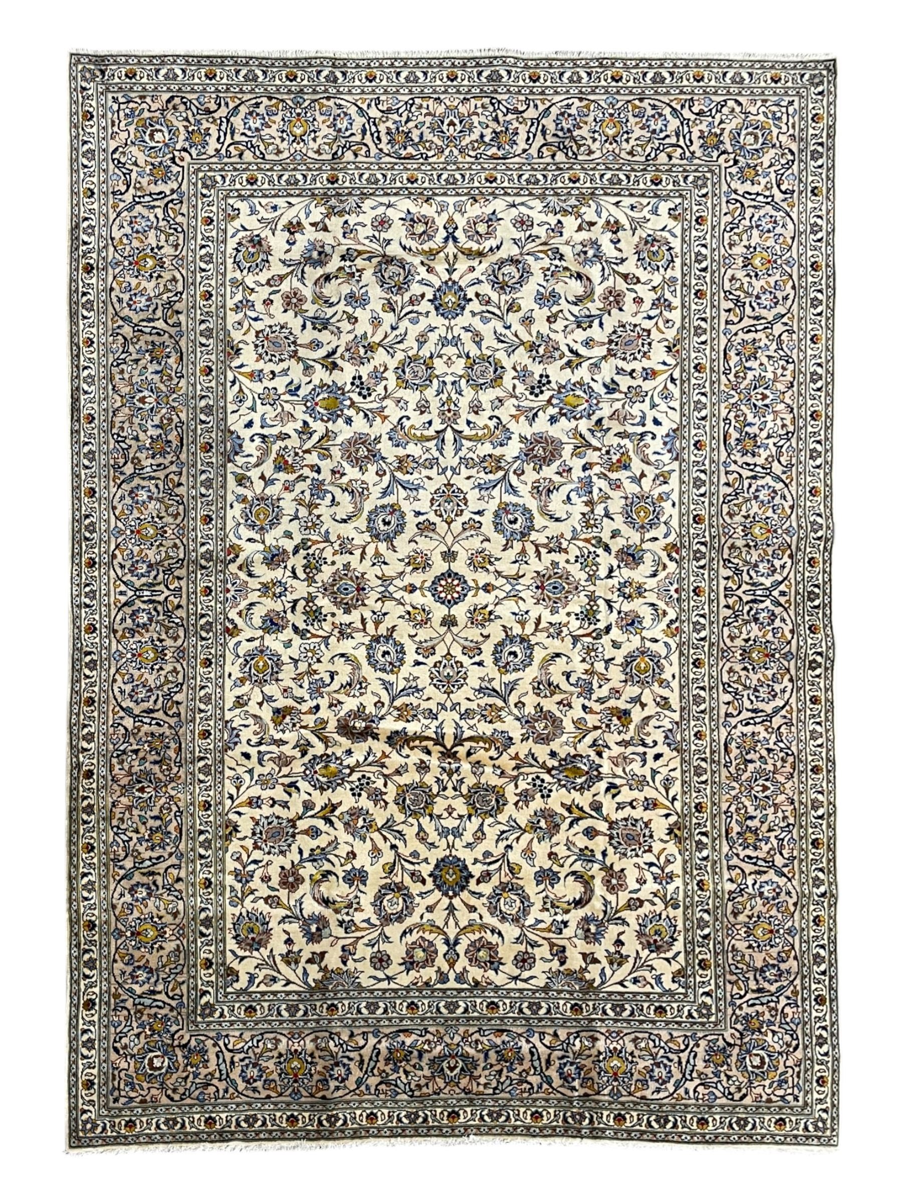 Persian Kashan Ivory ground carpet, the busy field decorated all over palmettes and trailing branches, scrolling border interspersed with stylised plant motifs, within guard stripes