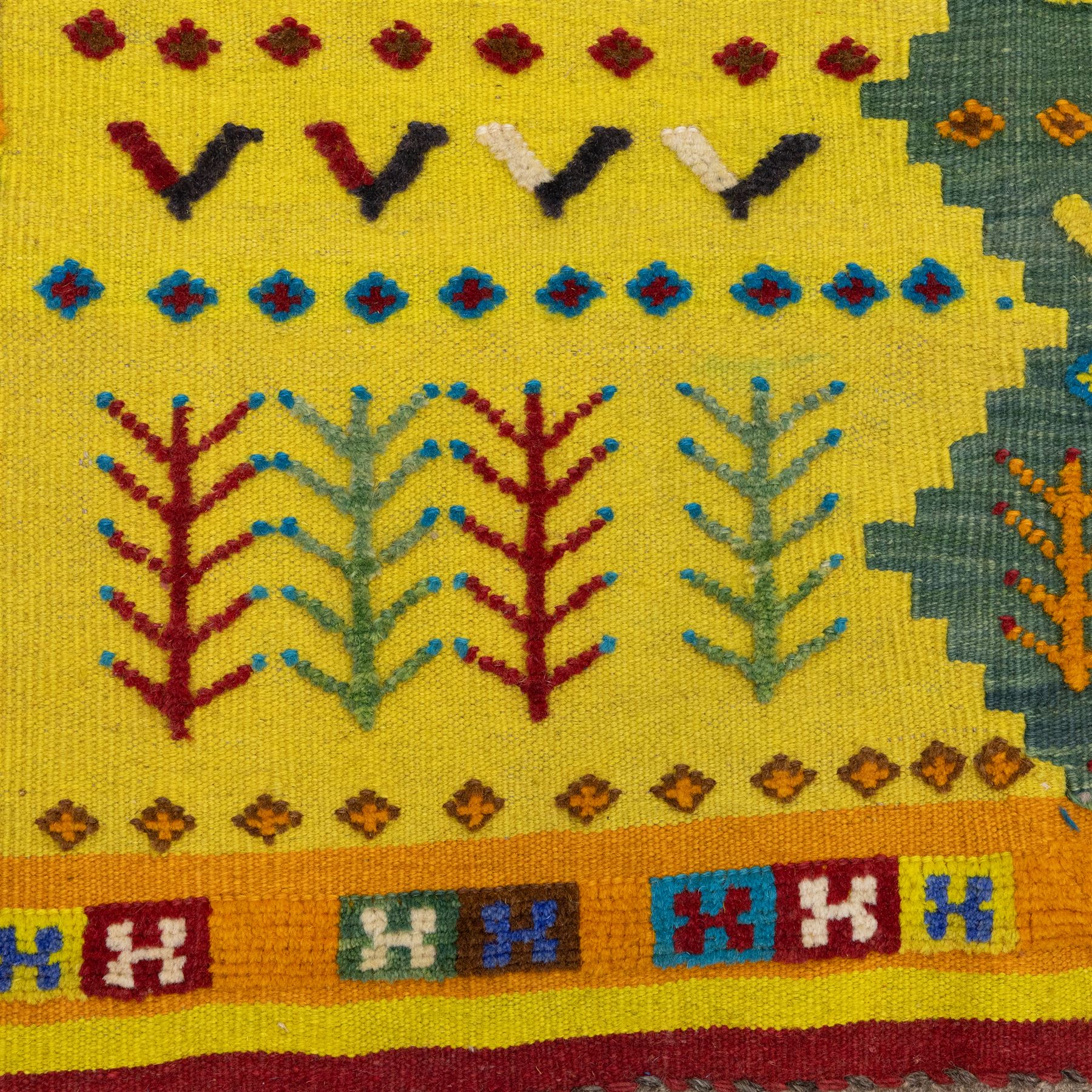 South West Persian Qashqai flatweave kilim, field arranged in bold horizontal bands of saffron yellow, madder red and deep green, decorated stylized tribal motifs including birds, animals, fish and schematic tree devices, composition arranged in a stepped asymmetrical format, with fringe ends 