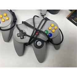 Nintendo 64 console, two controllers, games and accessories. Accessories to include the ‘Tremorpak’ and ‘Spook’ 2 Phono plugs and a S-VHS plug with adapter, both in original boxes. Games to include ‘Golden Eye 007’, ‘Doom 64’, ‘Killer Instinct Gold’, ‘Tetrisphere’, ‘F-1 World Grand Prix’, ‘Pilotwings 64’ and ‘Lylatwars’ with ‘Rumble Pak’, all with original boxes and instruction manuals. ‘Star Wars Episode I Racer’ game cartridge in Shadows of the Empire box. 