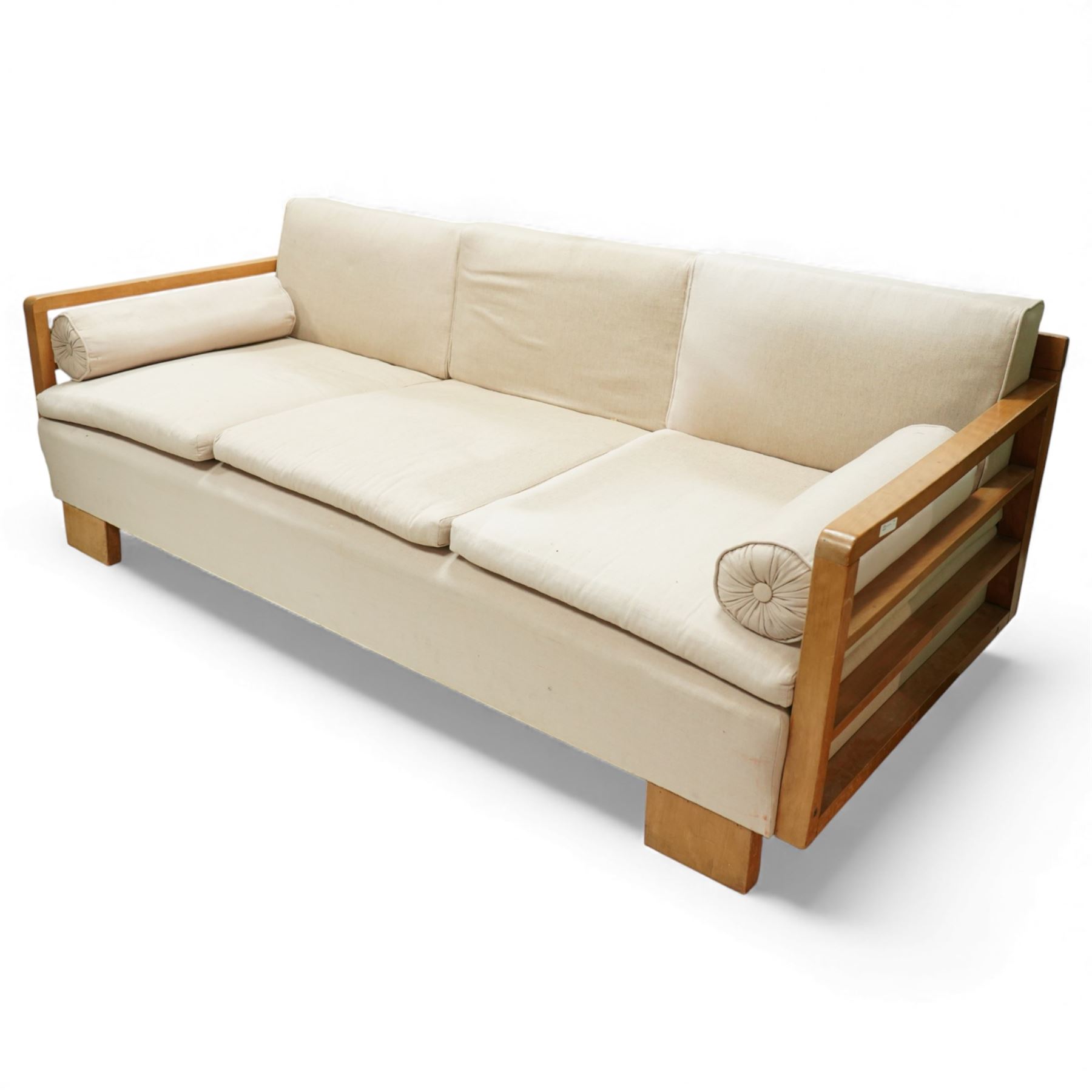 Mid 20th century German Art Deco oak framed divan day bed, rectangular form with slatted side supports, upholstered in cream linen with three removable back cushions, three seat cushions and cylindrical bolster arms, on block feet