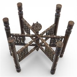 20th century Eastern brass charger topped table, the circular brass trap chased with an elephant, palm tress and flowering vines, supported upon a folding stand with six turned legs with inlaid detail, united by turned supports