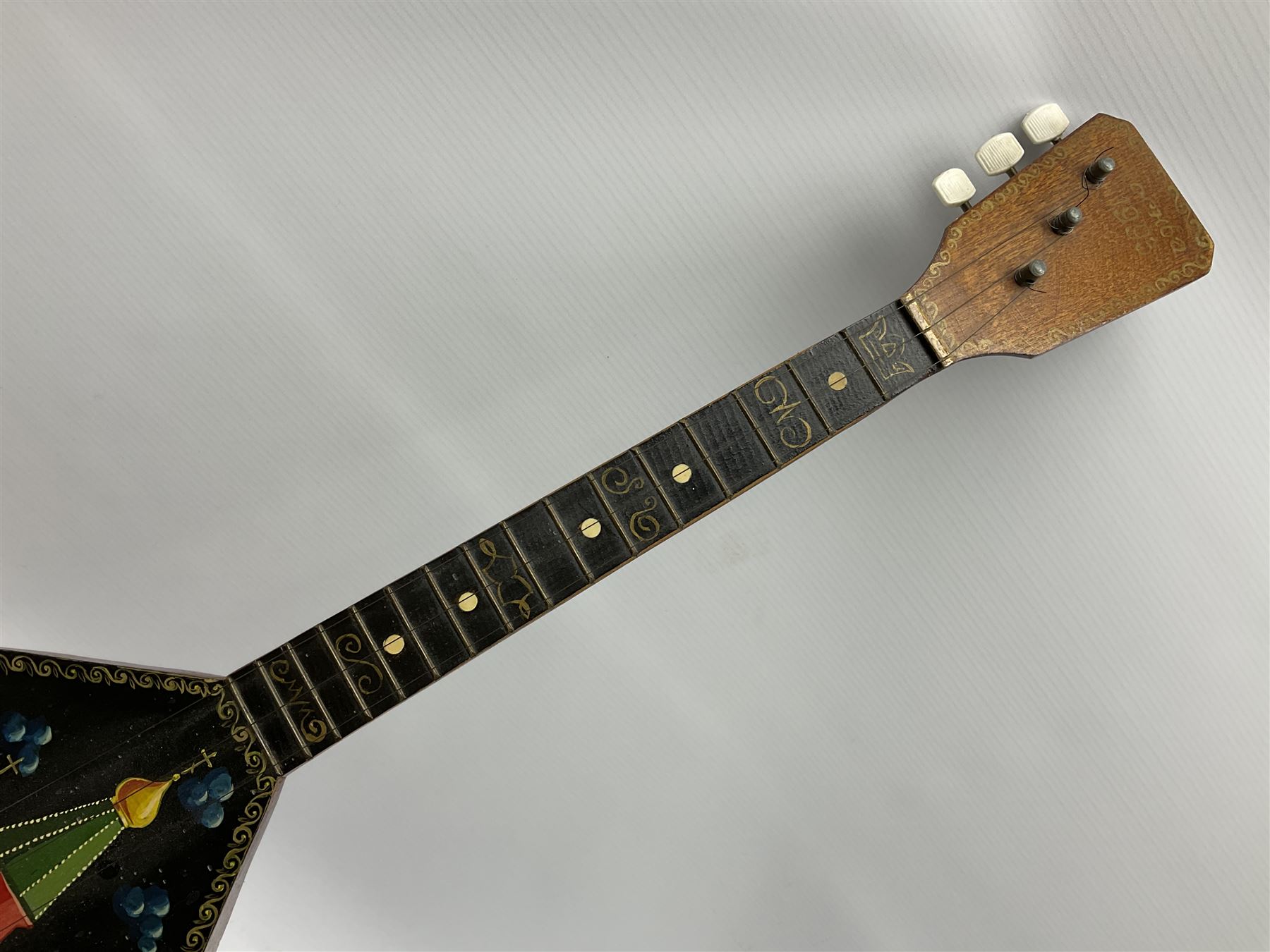 Russian balalaika with six-piece segmented back, the top painted with a scene of Russian onion capped buildings monogrammed K.B.H.1993; bears cyrillic label; L67.5cm; in carrying bag