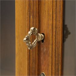 Pair of late 20th century Thai hardwood display cabinets, each with moulded cornice over twin glazed doors enclosing adjustable shelves, panelled cupboard doors below flanked by fluted columns, raised on bun feet