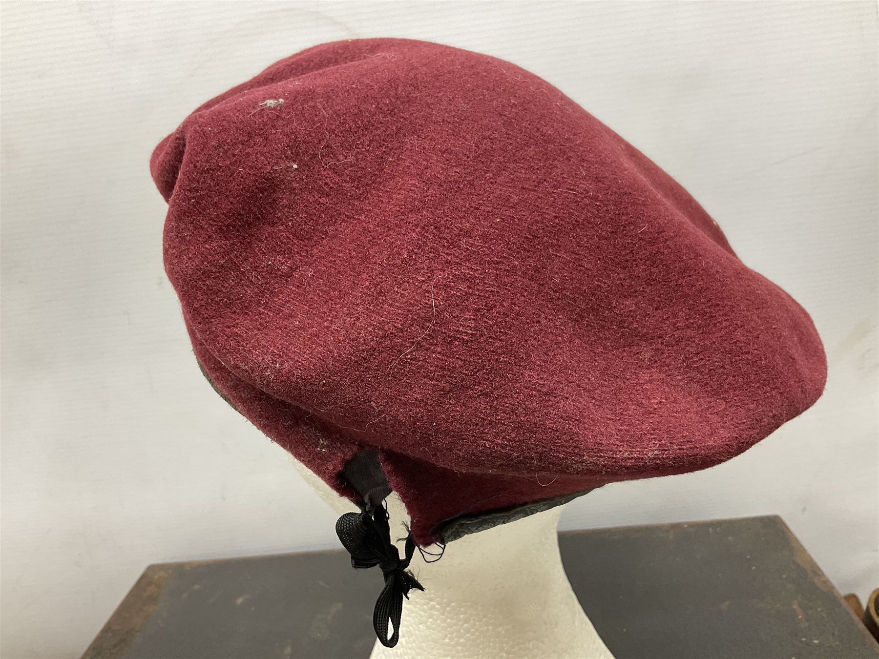 Assorted militaria including ten leather or canvas cartridge and other belts, maroon beret with 17th Lancers cap badge, modern bullet mould, leather and brass shot flask, two knives, shell cases, boomerang etc; in tin deed box