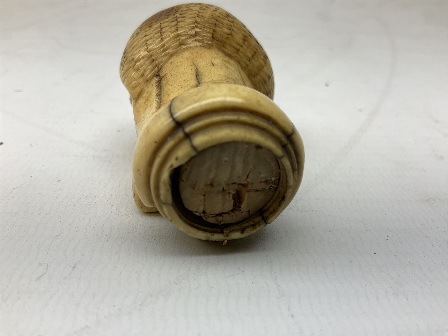 19th century carved ivory walking cane handle, modelled as the head of a greyhound with inset glass eyes, together with a further 19th century ivory example, modelled as a caricature of a gentleman's head, (2)