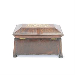 Early 19th century rosewood and brass inlaid tea caddy, of sarcophagus form, the front and hinged opening cover inlaid with brass scrolling panels, opening to reveal a compartmented interior with twin removable boxes with conforming inlaid brass detail to the hinged covers and zinc lining to the interiors, flanking a later glass mixing bowl, the whole upon four turned cylindrical feet, H21cm W36cm D20cm