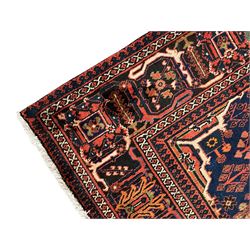 Persian Joshgan red ground rug, the medallion, field and spandrels decorated with clusters of Pitrak and tree of life motifs, the border with repeating design decorated with stylised plant motifs, within guard stripes