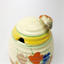 A Clarice Cliff Newport Pottery honey pot, modelled in the form of a beehive and decorated in the Crocus pattern, H10cm.