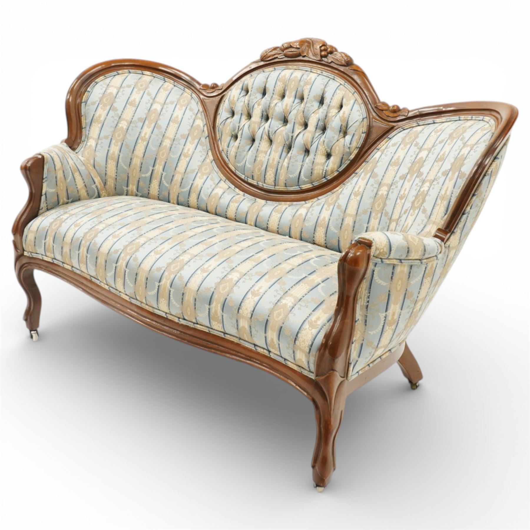 Victorian mahogany double cameo back sofa, the shaped back with central button upholstered oval panel and carved foliate crest above upholstered arms and seat, raised on cabriole legs terminating in castors