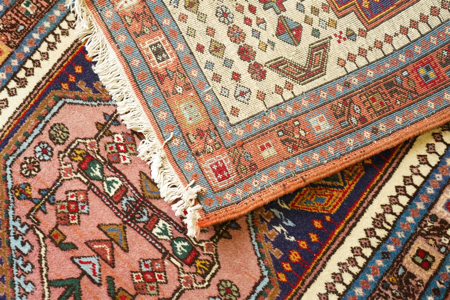 Persian Iranian wool runner, with a series of stepped hexagonal medallions in rust, olive and ivory against and deep navy field, the medallions are filed with floral and latch-hook motifs, framed by and ivory guard border with geometric rosettes, flanked by a rust outer band
