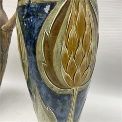 Early 20th century Royal Doulton stoneware vase, decorated with a stylized floral design below a wavy rim, monogrammed B.N, possibly for Bessie Newbery, H28cm, together with an early 20th century glazed jug, heavily carved throughout (2)