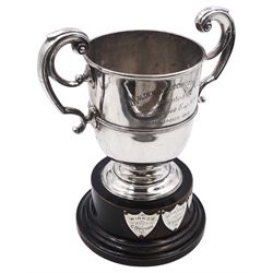 Early 20th century silver trophy cup, with twin scroll handles and reed border, the body with presentation engraving 'Malden & Cuddington Club, Presented by H.Keswick Esq MP, November 1913', hallmarked John Round, Sheffield 1913, upon an ebonised plinth with three applied silver winner's shields, cup including plinth and handles H21.2cm, approximate silver weight 9.27 ozt (288.2 grams) 