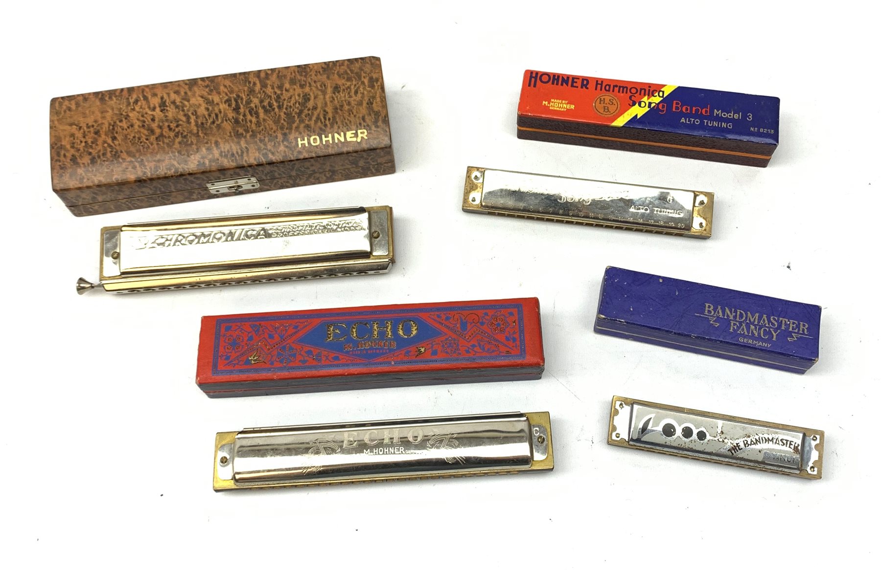 A group of four cased Harmonicas comprising a Hohner 64