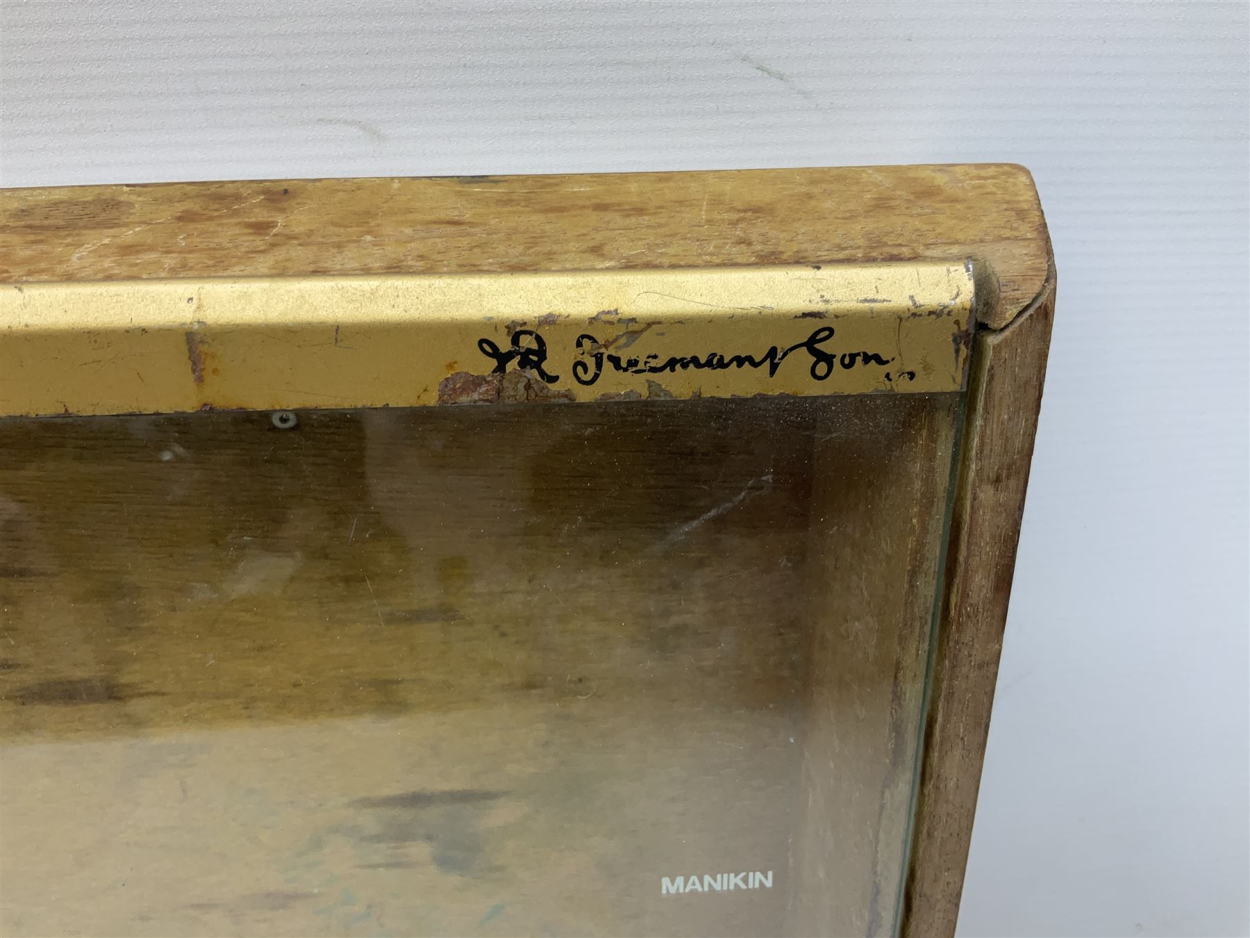 Benson and Hedges countertop glazed display cabinet, the glass hinged lid with white labelling of various cigarettes and cigars, the gilded metal bands with black lettering, W38cm D33cm H8cm