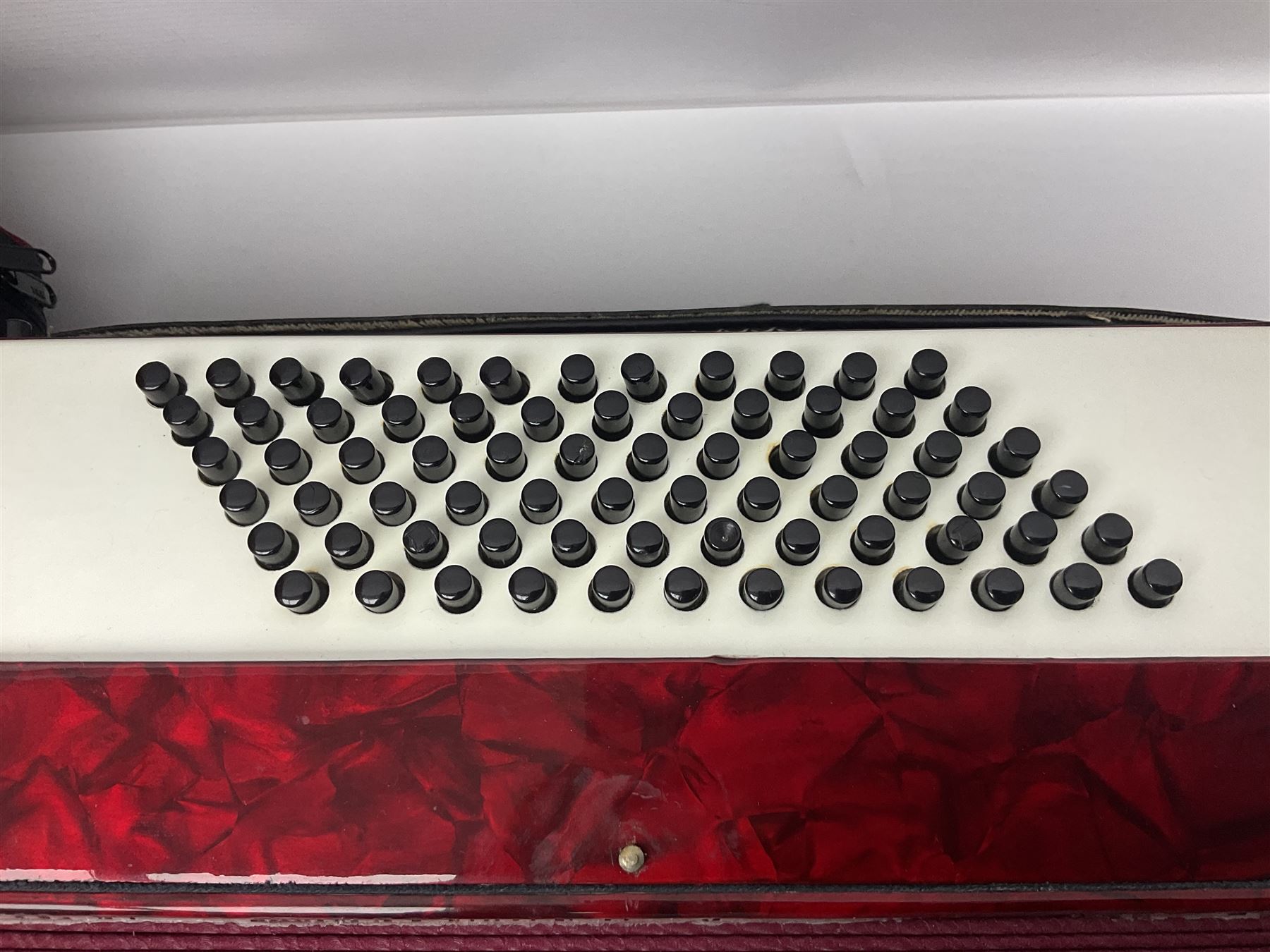 Hsinghai Studio piano accordion with red pearline finish, twenty keys and seventy-two buttons W44cm; in hard carrying case with additional The Music Room soft gig case