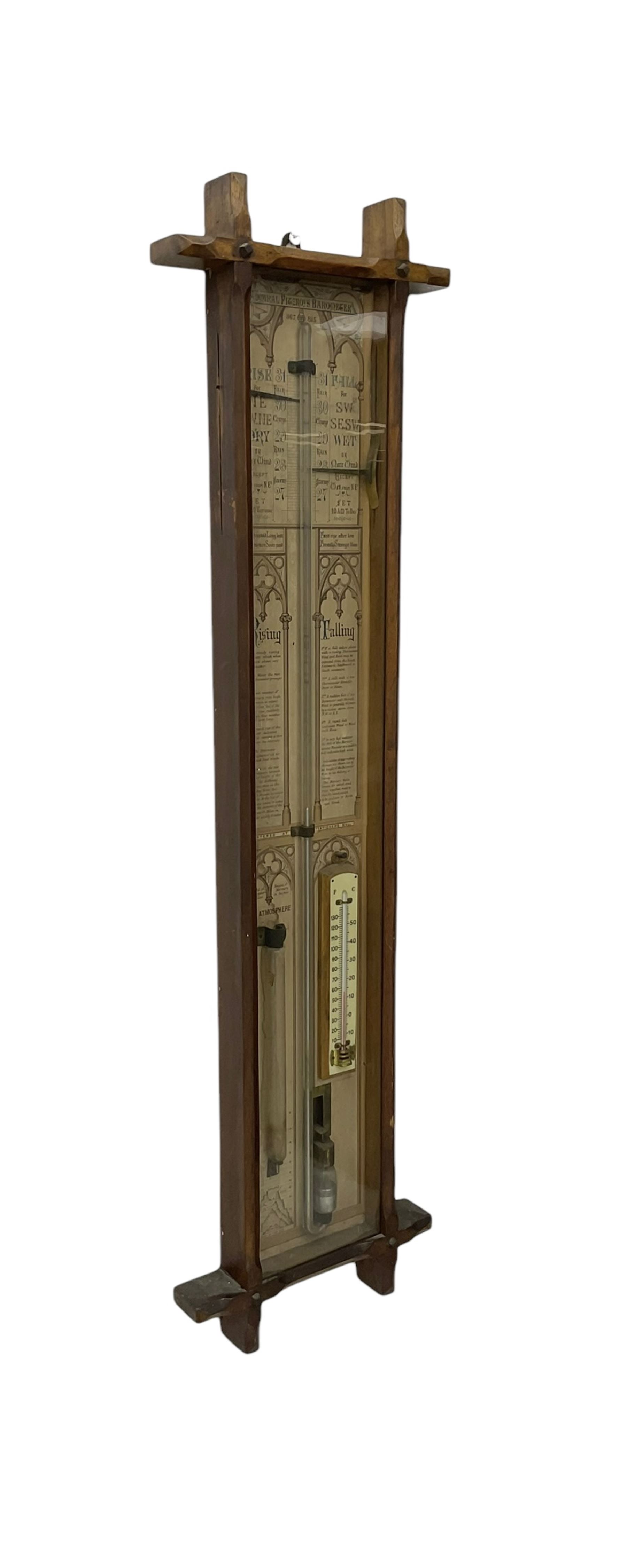 Oak cased Admiral Fitzroy barometer c1890 - with original full height paper scales annotated with Fitzroy's remarks and observations, brass sliding pointers above a Fahrenheit and centigrade spirit thermometer and storm glass, large bore bulb cistern tube with a mechanical sealing tap, in a fully glazed reformed gothic influenced case with chamfered moulded uprights, top, and base.
